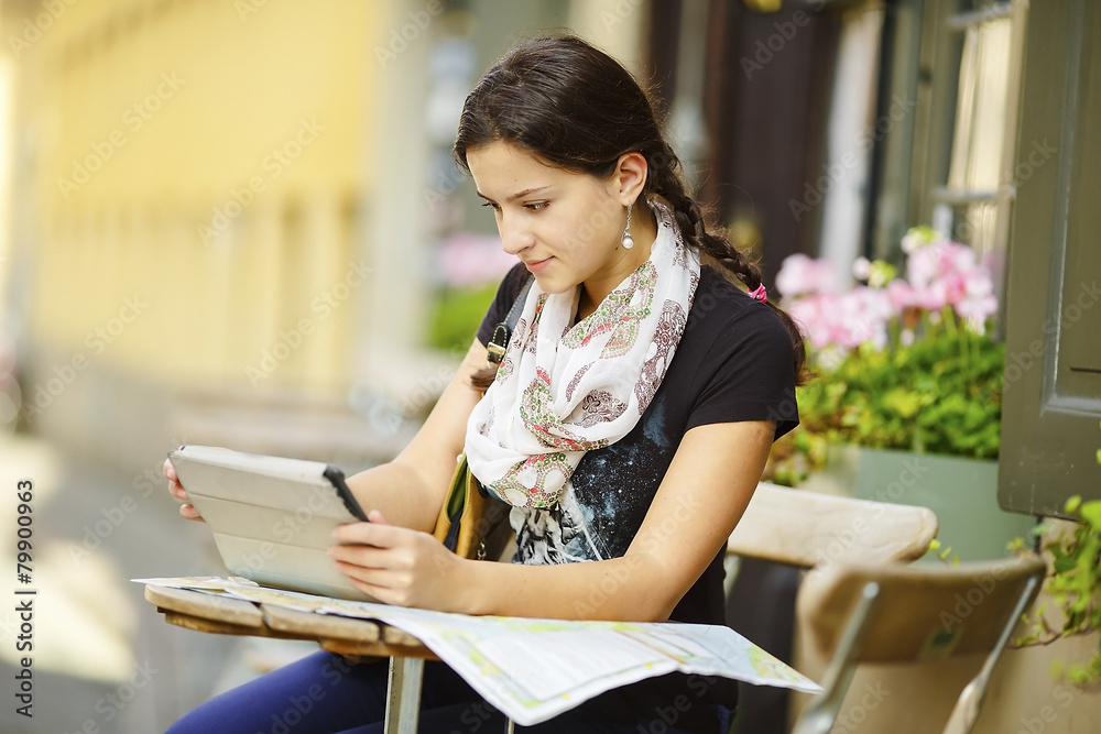 Beautiful girl sitting in a cafe working with tablet computer Beautiful girl sitting in a cafe working with tablet computer