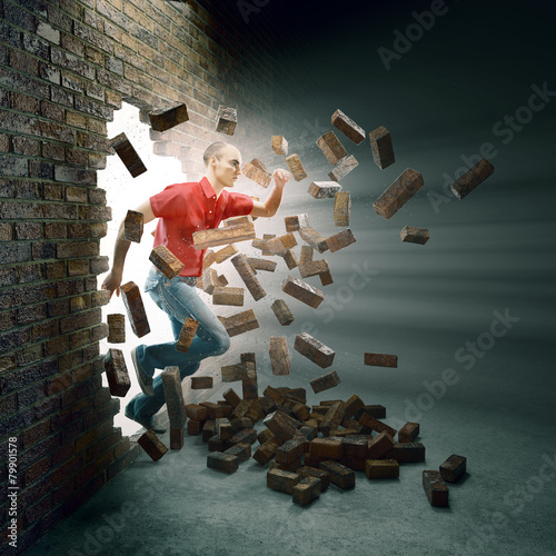 Man running through a brick wall photo