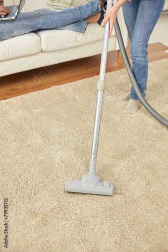 close up of couple legs and vacuum cleaner at home