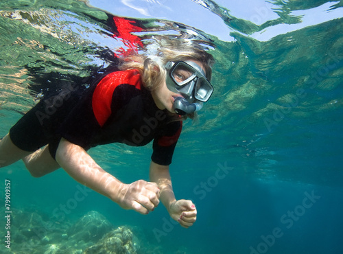 Young woman snorkeling in clear tropical sea