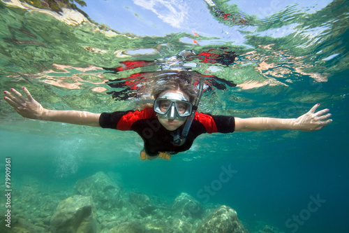 Young woman snorkeling in clear tropical sea