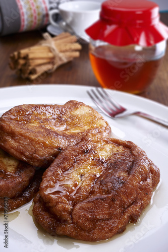 French toast on a plate, and bottom cinnamon, honey and coffee