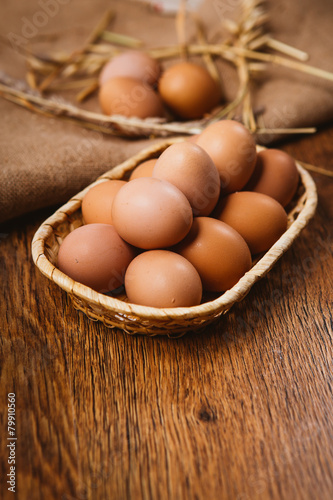 fresh brown eggs and wheat on linen background