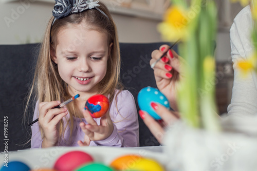Little girl and mother coloring eggs for Easter