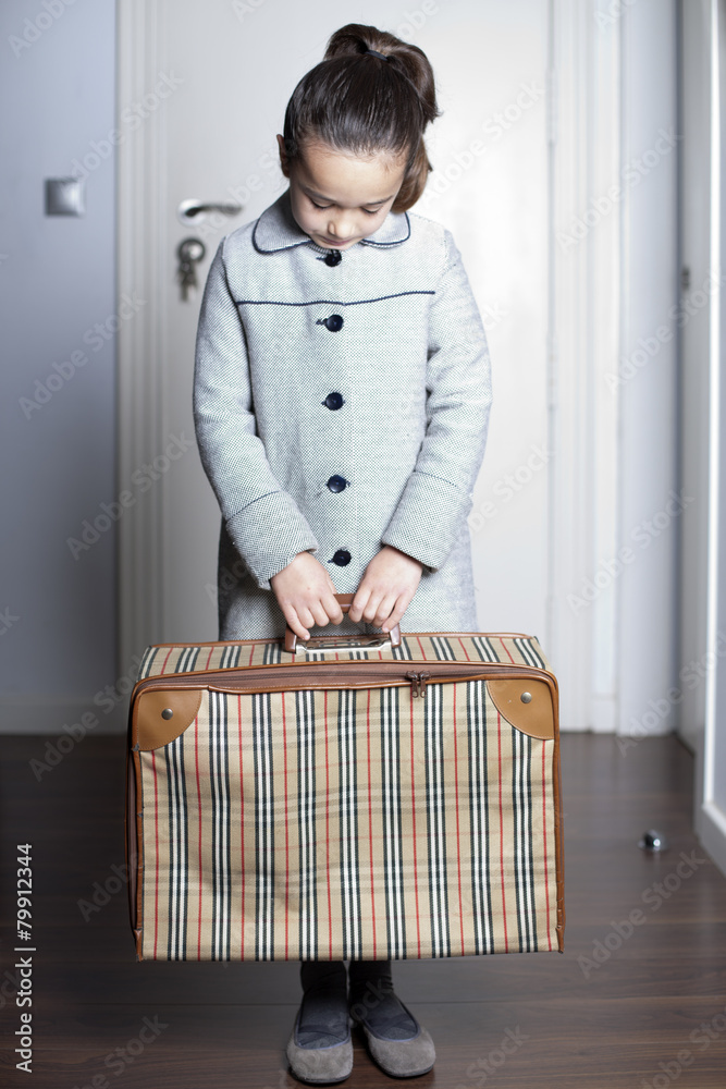 Niña con maleta en mano vuelve arrepentida a casa Stock Photo | Adobe Stock