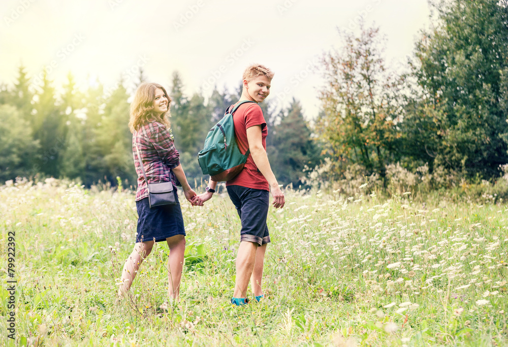 Young couple on the walk in summer forest