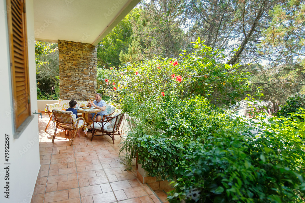 Father and son having breakfast together outdoors