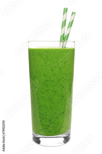 Green smoothie in a glass with straws isolated on white