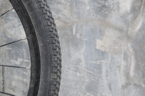 Dirty bike wheel-Concrete background.