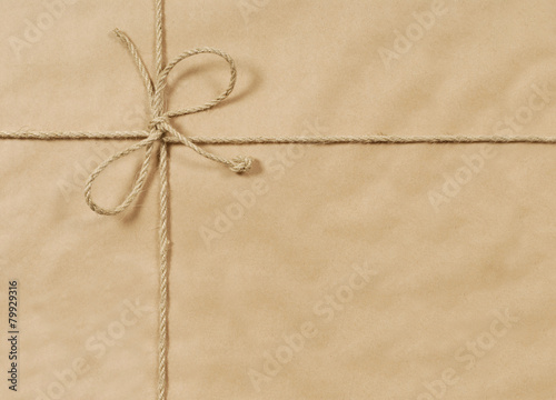 Obraz na płótnie Brown paper package parcel background tied with string or rope photo