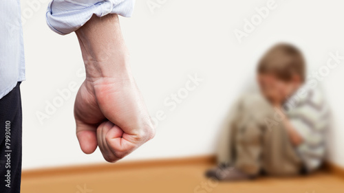 Angry man raised fist over wall corner sitting child boy