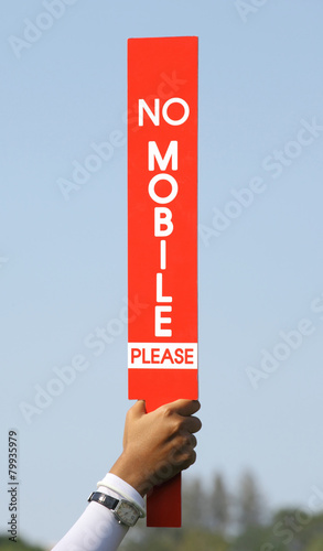 The no mobile sign was held up by volunteer in golf tournament.