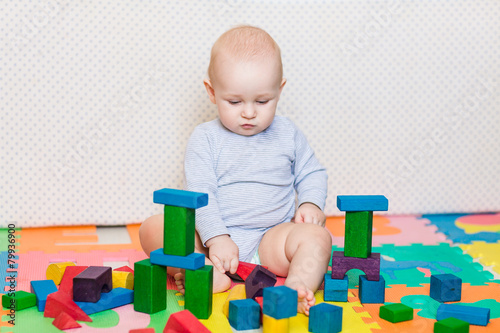 Cute little baby playing with colorful toys