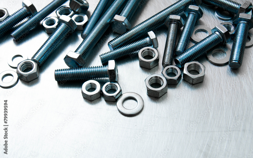 Nuts, washers and bolts on scratched metal background. Nuts, washers and bolts on scratched metal background.
