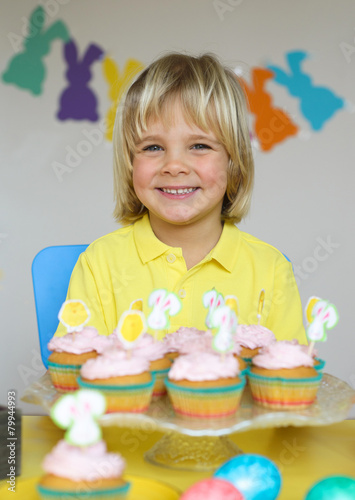 Smiling  little boy with cupcakes in Easter scene