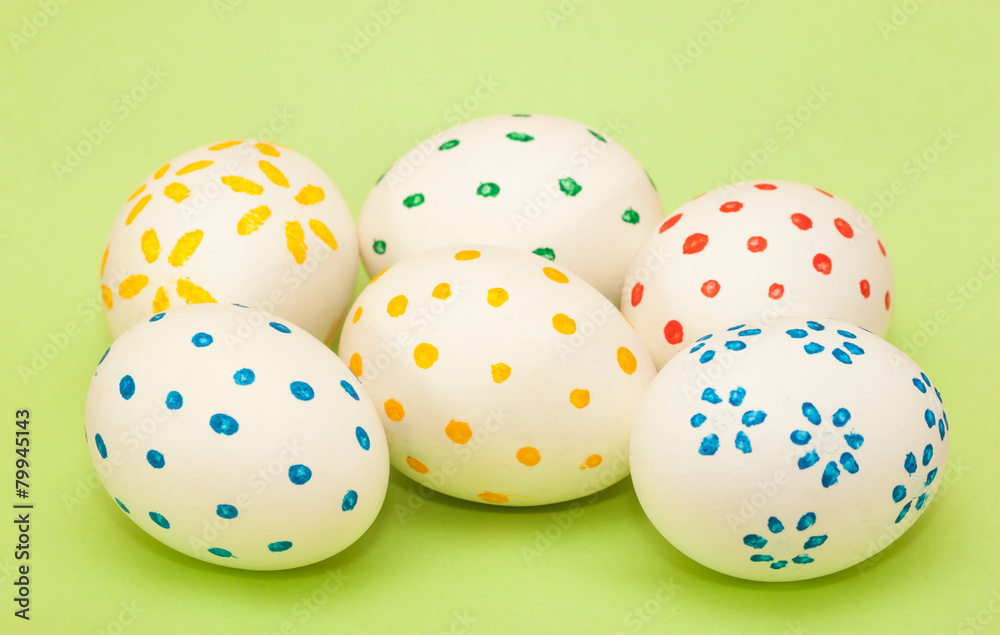 six spotted easter eggs on green background
