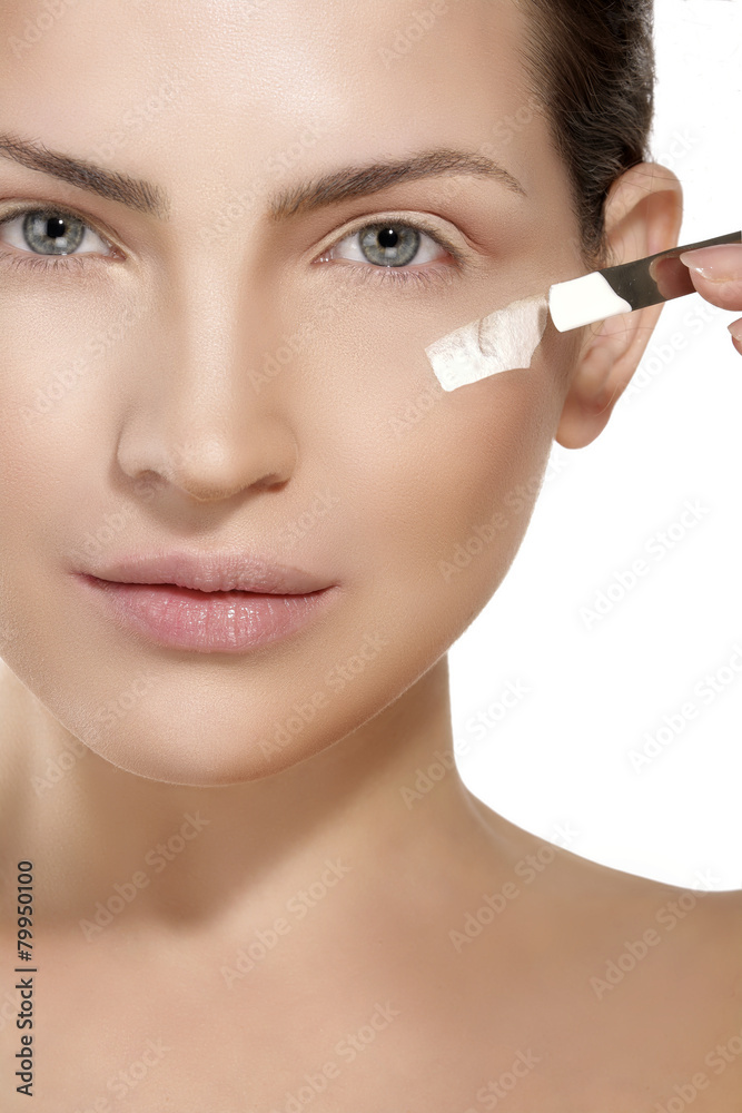 Beautiful model applying foundation with a brush Beautiful model applying foundation with a brush