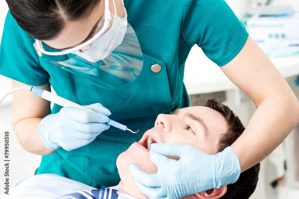 Professional dentist doing teeth checkup Professional dentist doing teeth checkup