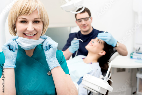 Male dentist doing teeth checkup behind