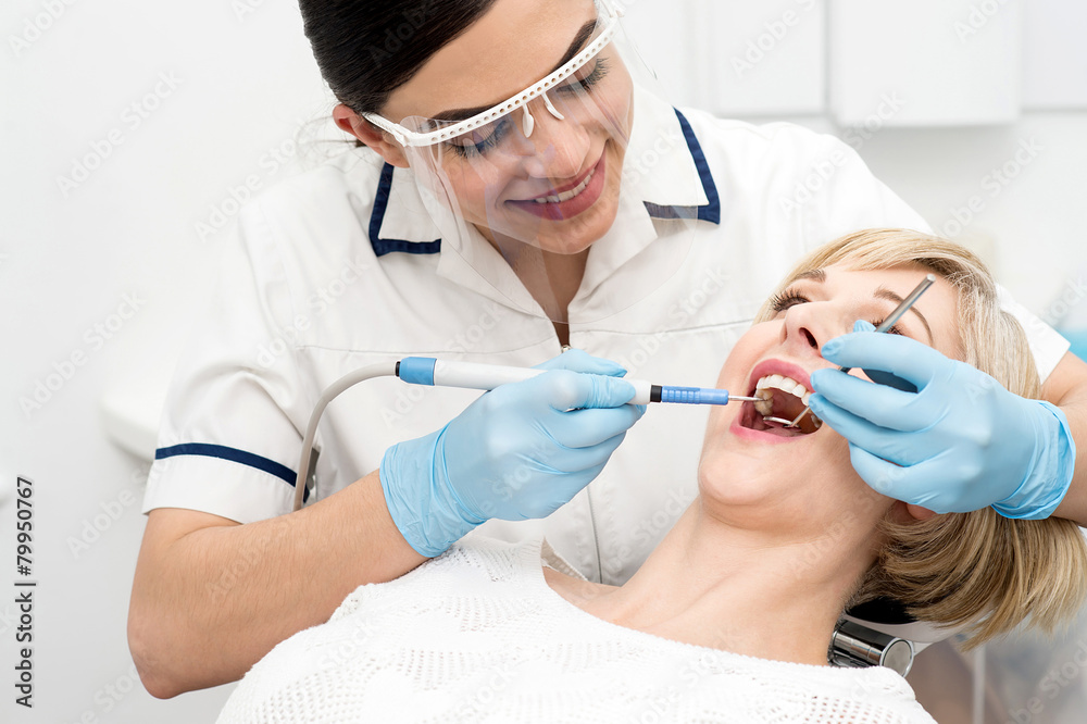 Dentist curing a woman teeth Dentist curing a woman teeth