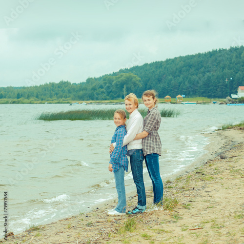 mother and her two daughters on the shore