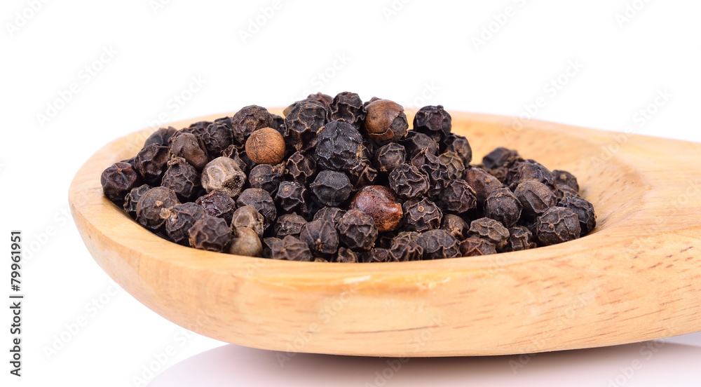 Black pepper on wooden spoon on white background Black pepper on wooden spoon on white background