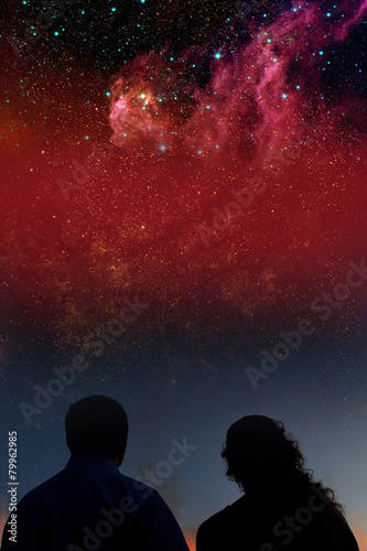 Silhouettes of couple looking at stars. Starry night sky with