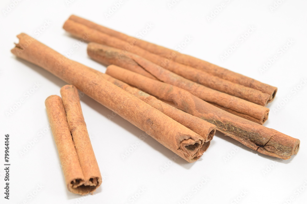 Cinnamon sticks stacked on white background.