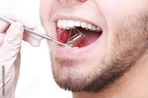 Examine of young man by dentist closeup