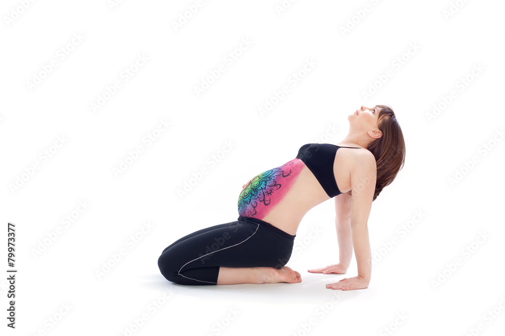 Woman with painted belly doing yoga exercise