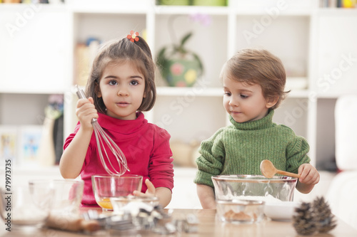 Children playing in the kitchen and learning how to bake