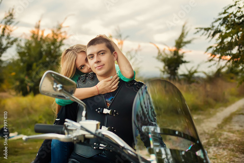 Young couple with beautiful bike on road.