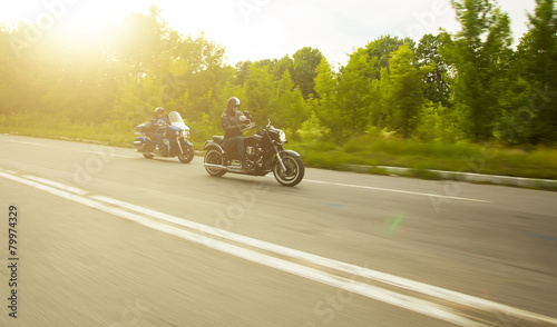 slow motion, two bikers riding unknown motorbike with blur movem