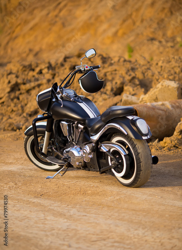Fototapeta Big, clean, black and unknown chopper bike in desert