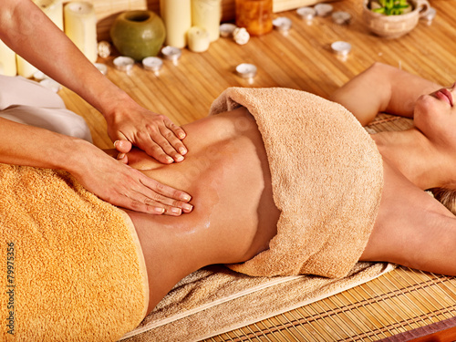 Woman getting massage in bamboo spa.