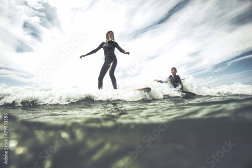 France, Bretagne, Camaret sur Mer, Teenage girl surfing at Atlantic coast photo