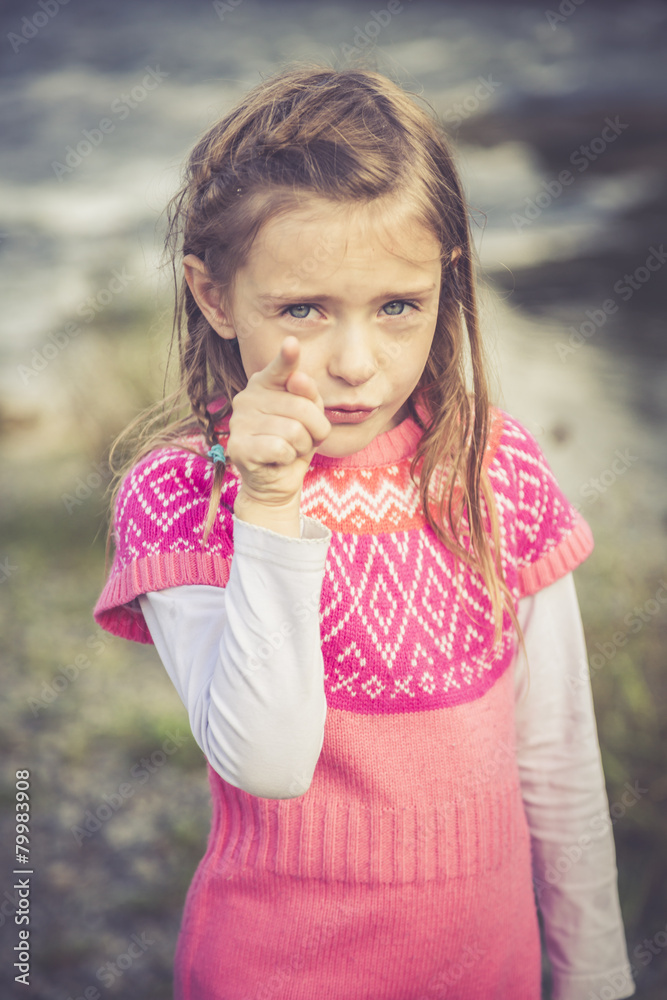 Portrait of little girl pointing at viewer Portrait of little girl pointing at viewer