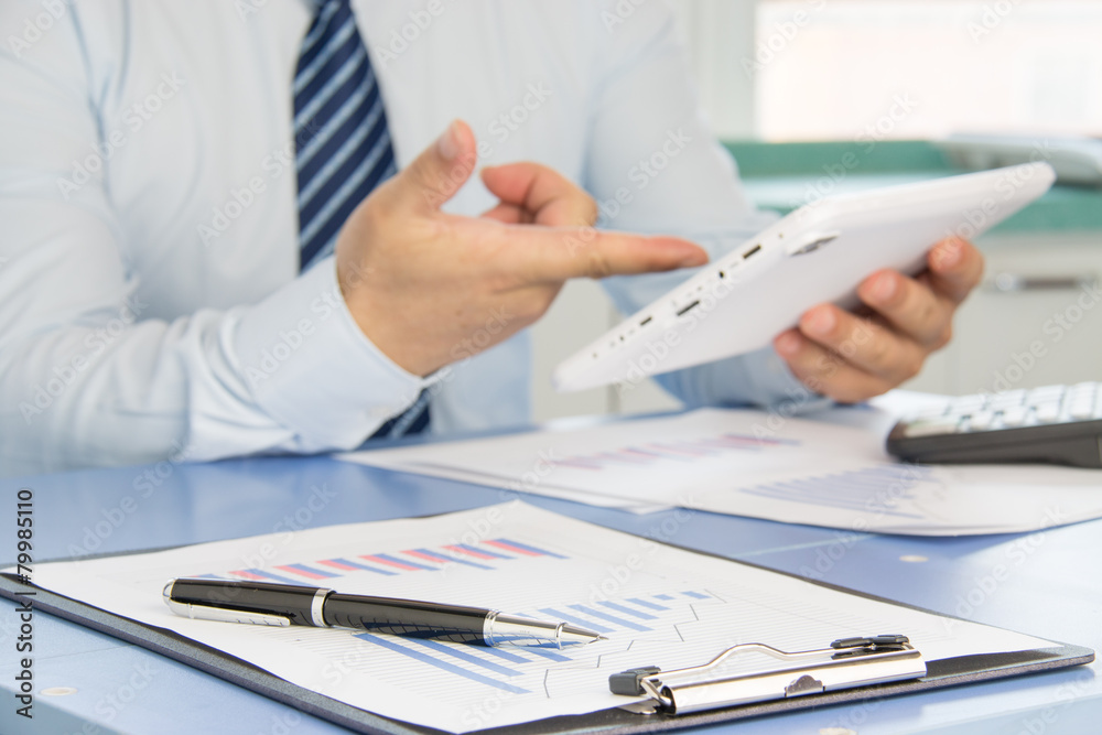 Businessman analyzing financial statements in the office Businessman analyzing financial statements in the office
