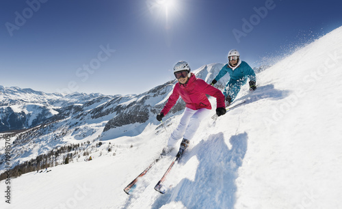 Austria, Salzburg, Young couple skiing on mountain photo