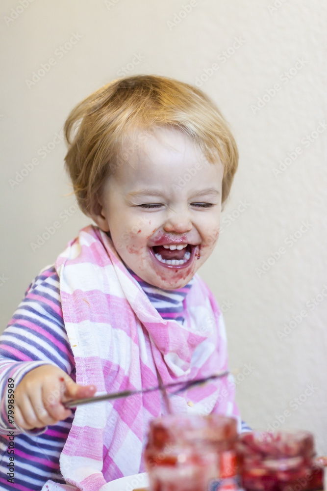 Portrait of laughing little girl covered with red jam Portrait of laughing little girl covered with red jam