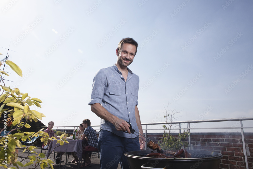Germany, Berlin, Portrait of man barbecuing on grill, smiling Germany, Berlin, Portrait of man barbecuing on grill, smiling