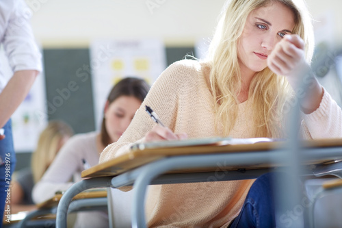 Female student in classroom cheating during an exam photo