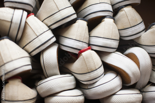 Pile of white canvas shoes photo