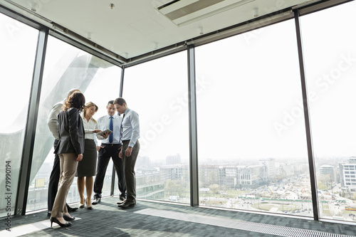 Businesspeople in office with woman using digital tablet photo