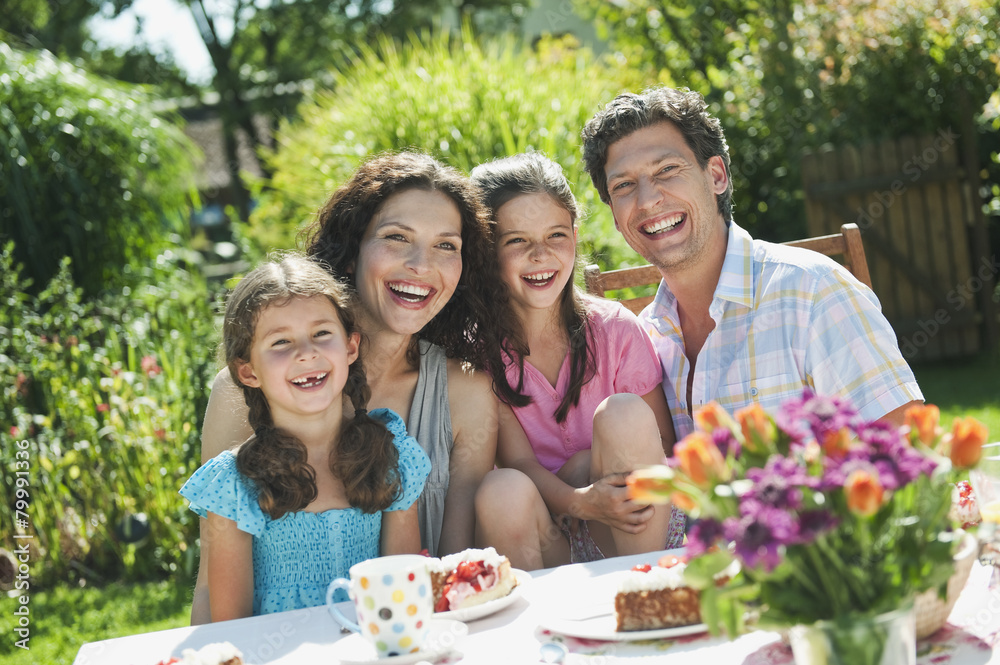 Germany, Bavaria, Family having coffee and cake in garden, smiling Germany, Bavaria, Family having coffee and cake in garden, smiling
