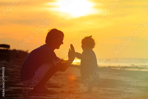 Father and little daughter playing silhouettes at sunset © nadezhda1906