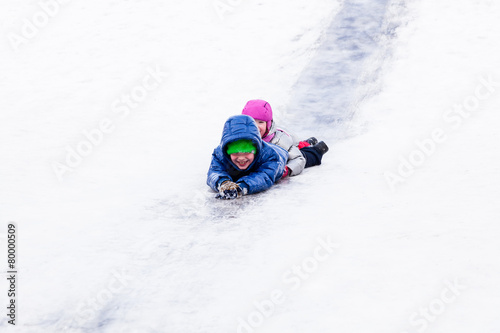 Children riding the hills in winter