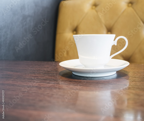 Coffee cup on table in restaurant cafe with sofa background