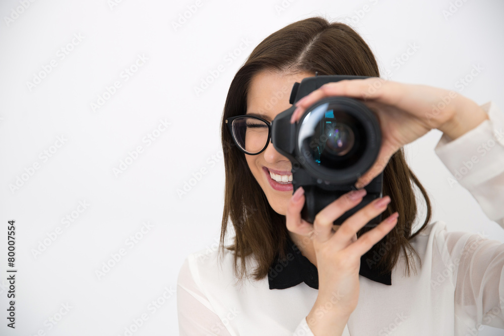 Smiling female photographer with camera over gray background