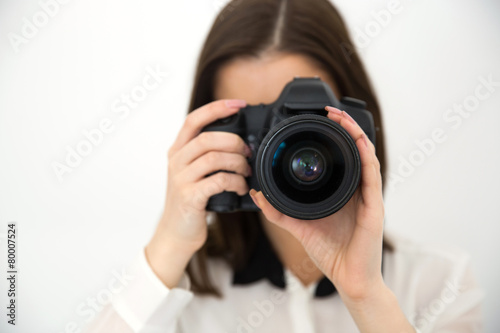 Woman photographer with camera over gray background